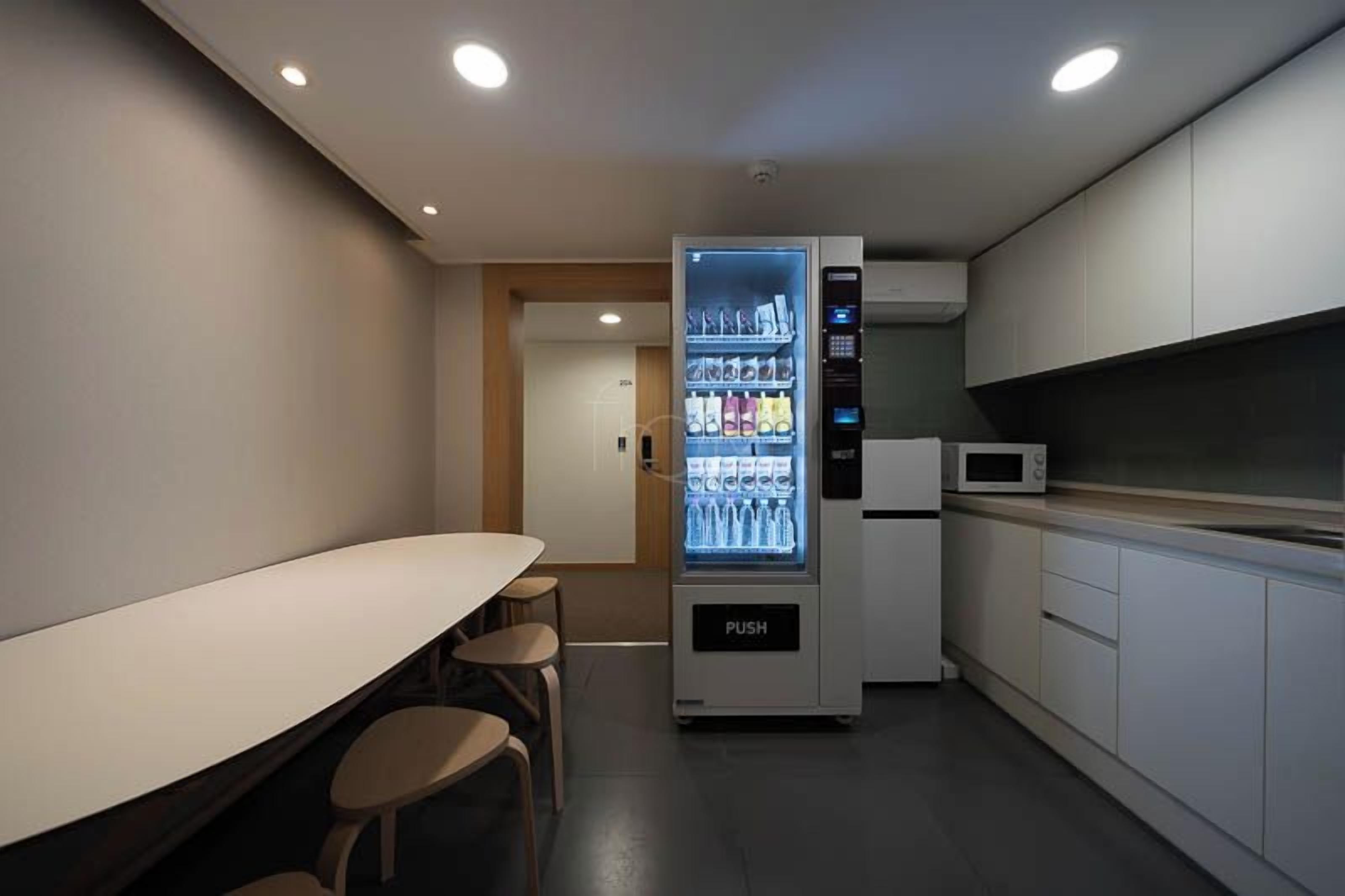 Una cocina moderna con una máquina expendedora, un microondas y una zona de bar.
