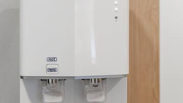 A Ruens branded water dispenser with hot, cold, and eco settings, and a power button.