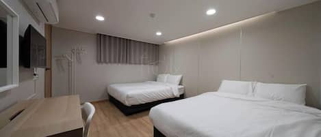 Una habitación de hotel con dos camas, un escritorio y una televisión.