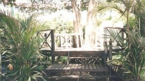 A wooden deck with a metal railing, surrounded by potted plants. - Perhentian Tropicana Inn (Pulau Perhentian Kecil)