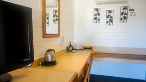 A hotel room with a television, a kettle, a small table, and a view of the outside. - Country Ayr Motel (Ayr)
