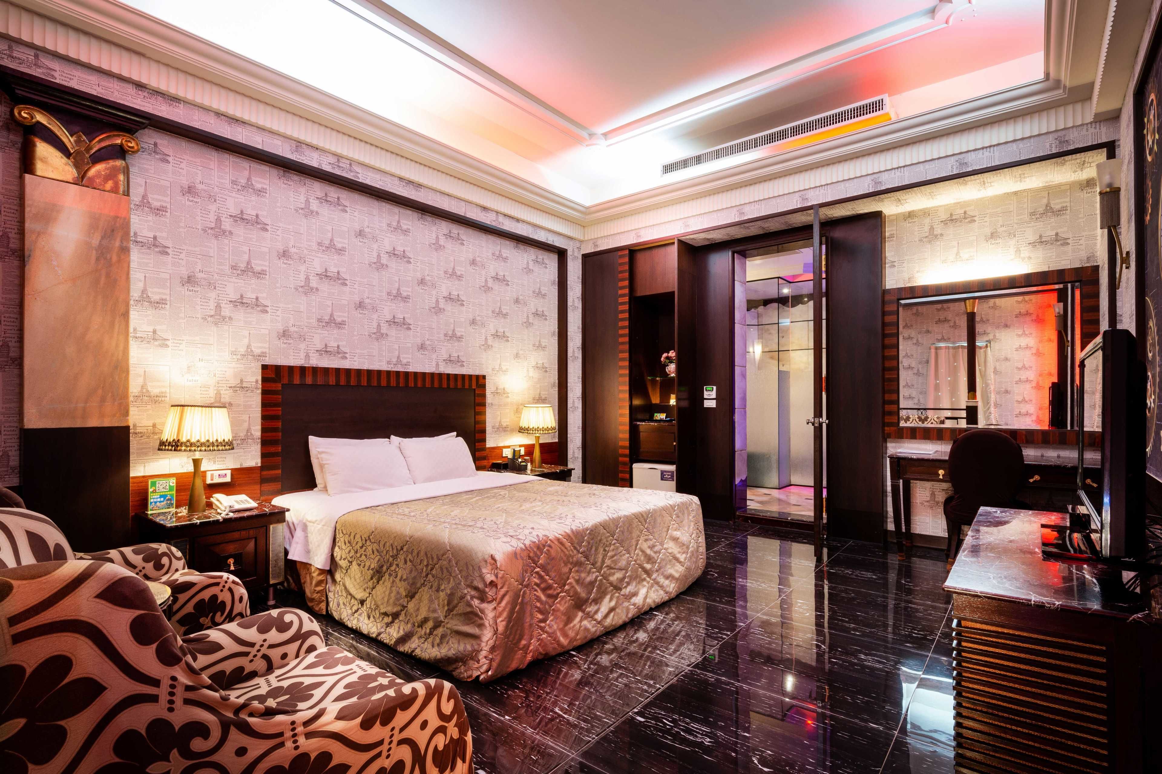 Une chambre d’hôtel spacieuse, dotée d’un grand lit, d’un bureau et d’un miroir de coiffeuse.
