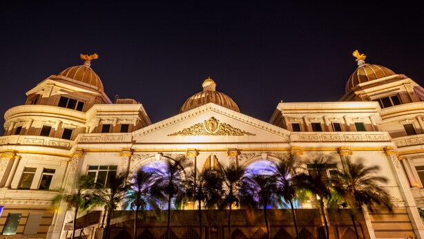 Un edificio imponente con tres cúpulas y una entrada central ricamente decorada.