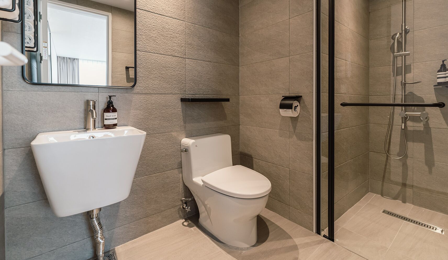 A modern bathroom with a toilet, sink, and shower.