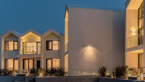 A modern multi-story building with balconies, large windows, and a well-lit exterior. - Albescent Pool Villa (Gyeongju)