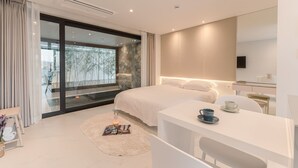 Un dormitorio moderno con una cama grande, un escritorio y una televisión.