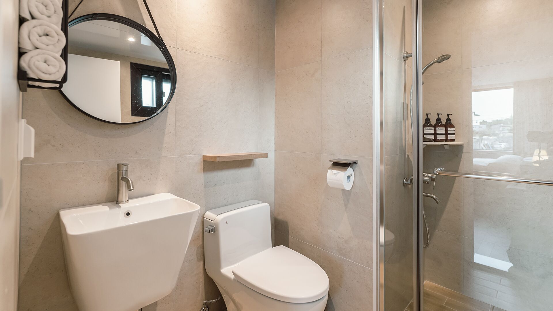 A modern bathroom with a sink, toilet, and glass-enclosed shower.