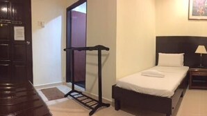 A hotel room with two single beds, a nightstand with a lamp, a dresser, and a mirror on the wall. - Perhentian Tivoli Inn (Pulau Perhentian Kecil)