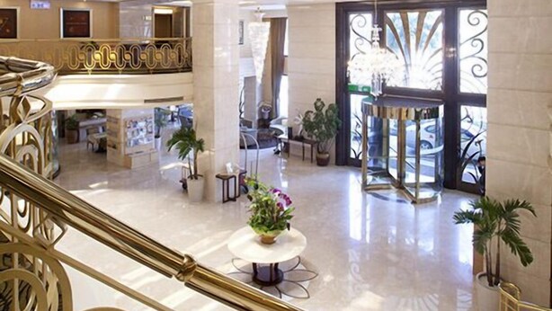 A multi-level atrium with a grand staircase, polished floors, and decorative railings. - Justwin Grand Hotel (Tainan)