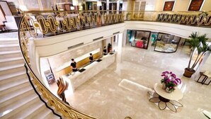 A spacious lobby with a marble floor, a reception desk, and a staircase with ornate railings. - Justwin Grand Hotel (Tainan)