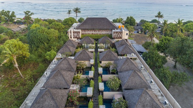 A resort with multiple thatched-roof villas, a central pool, and a view of the ocean. - d’Nusa Beach Club and Resort (Lembongan Island)