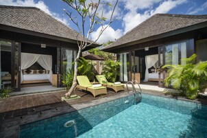 Uma área à beira da piscina com duas espreguiçadeiras, uma piscina pequena e um espaço coberto para sentar, com vista para a piscina.