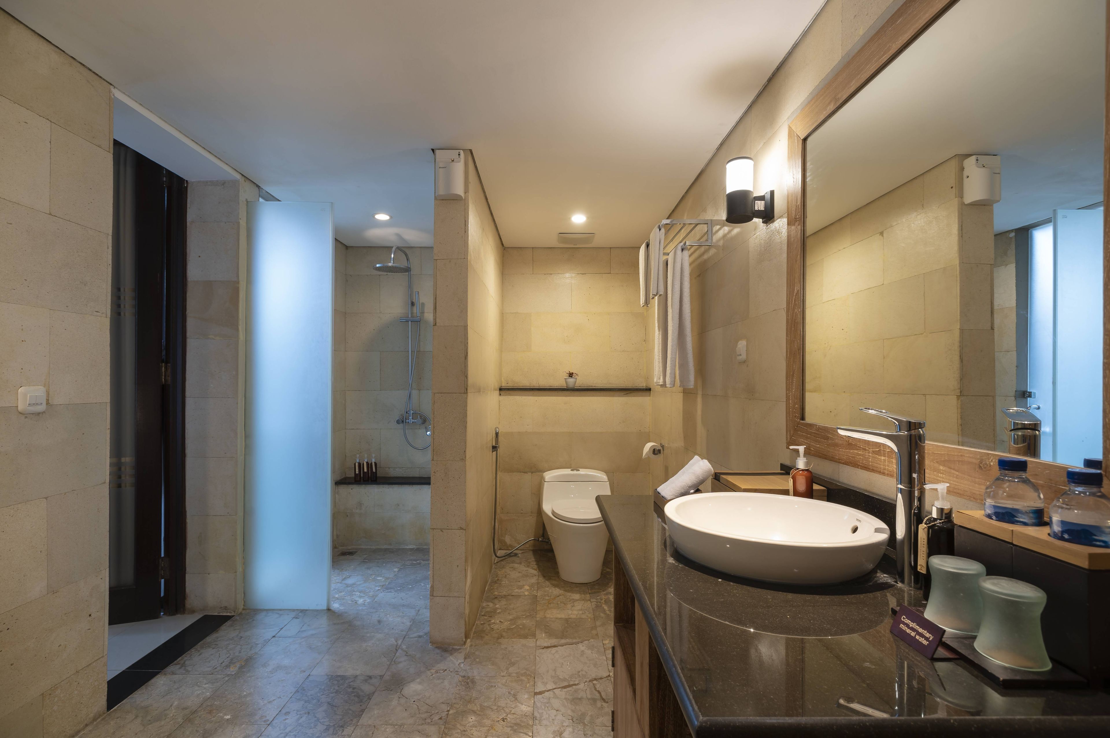 Un baño moderno con lavamanos grande, espejo y ducha.