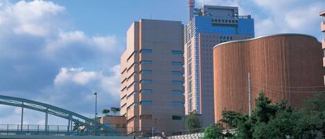 A multi-story building with a modern design, a bridge, and a staircase leading to the building.