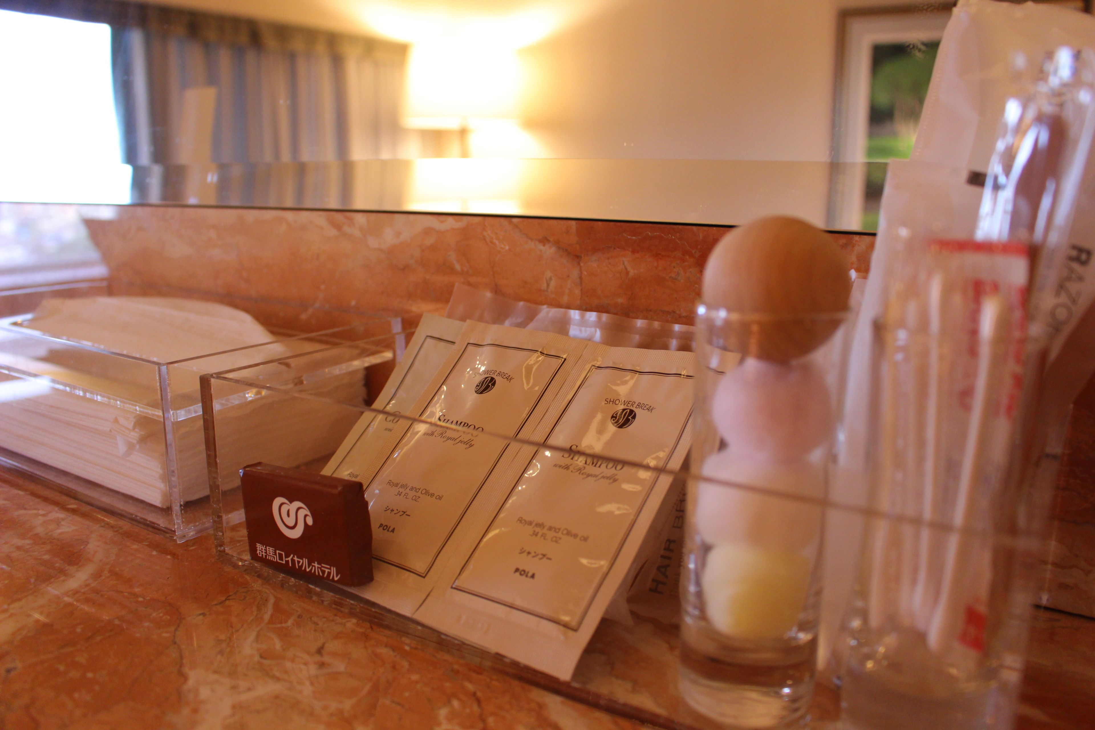 A hotel reception area with a marble counter displaying various toiletries and a small brown box labeled in a foreign language.
