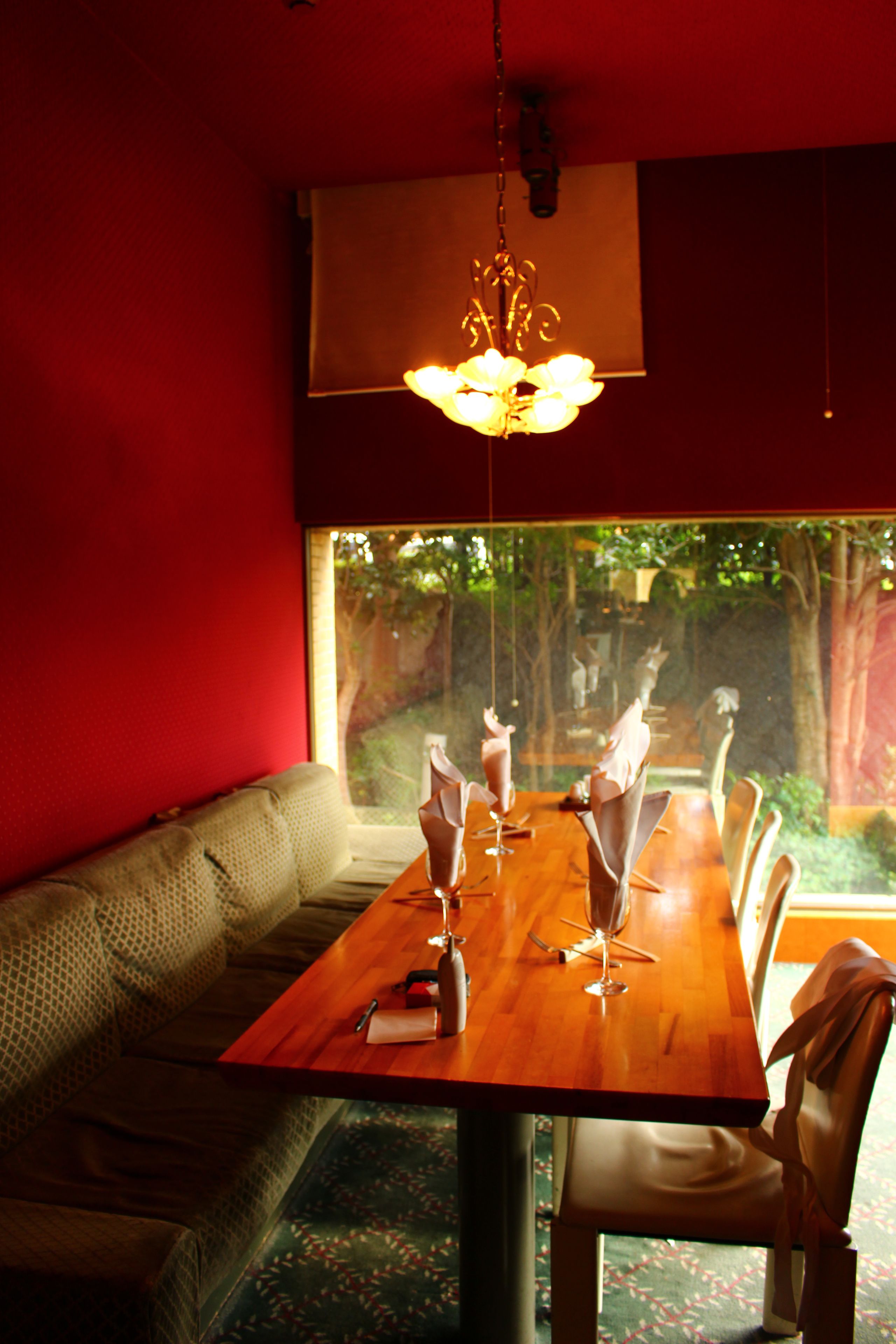 Un comedor con una mesa de madera, sillas y una lámpara colgante.