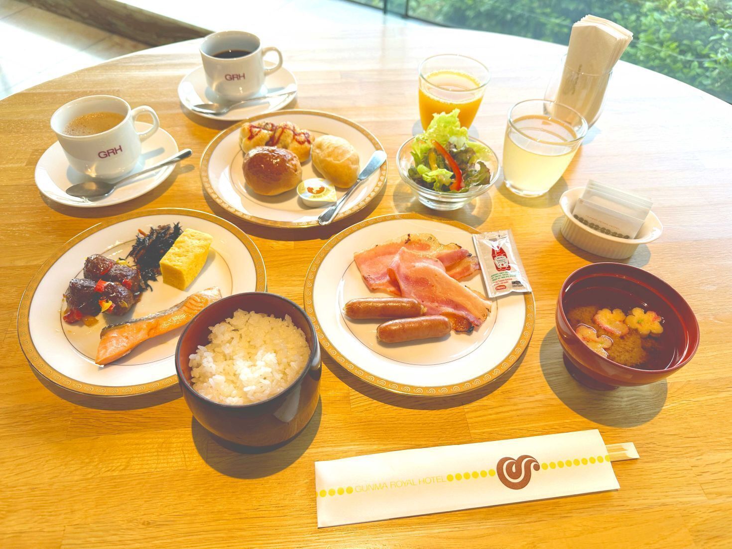 A table with various dishes including sushi, sashimi, rice, and a bowl of soup.