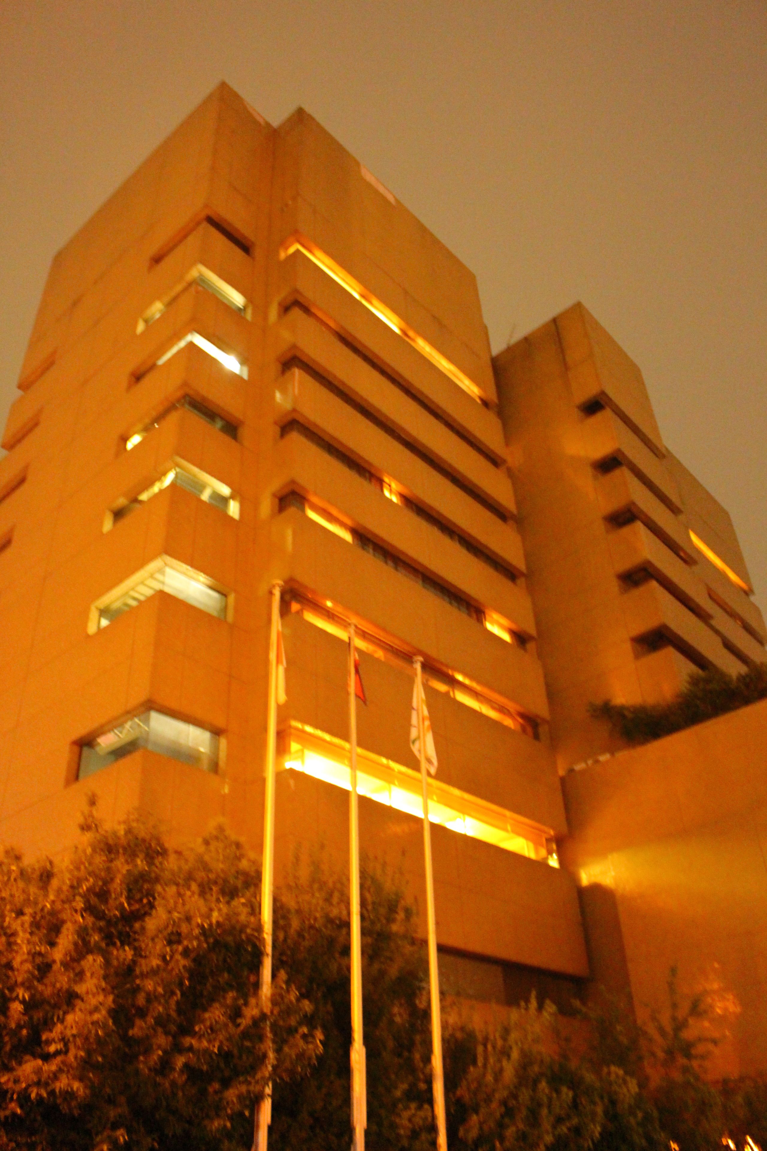 Um edifício alto e moderno, com vários andares e grandes janelas.