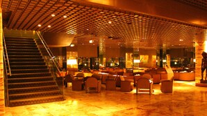 A lobby with a staircase, seating area, and a reception desk. - Gunma Royal Hotel (Maebashi)