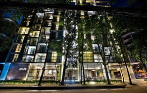 A modern building with multiple floors, large windows, and a well-lit entrance area. - Space Apartments (Dhaka)