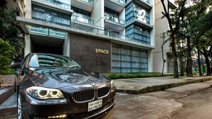A black BMW parked in front of a building with a sign that reads "SPACE". - Space Apartments (Dhaka)