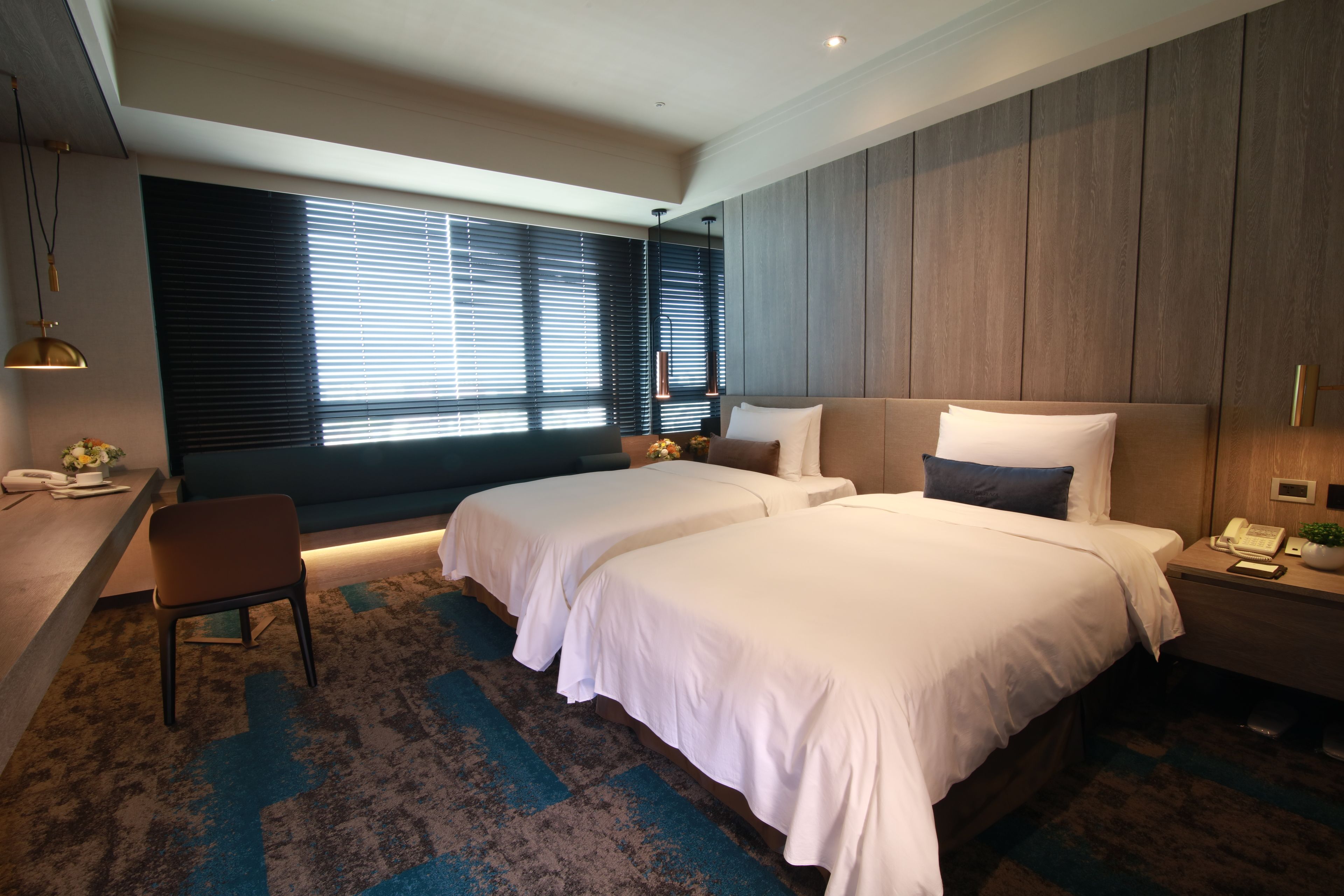 Una habitación de hotel moderna con dos camas, un escritorio y una silla.