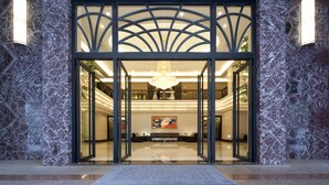 A grand entrance with a marble facade, a glass door, and a chandelier. - Queena Plaza Hotel Tainan (Tainan)