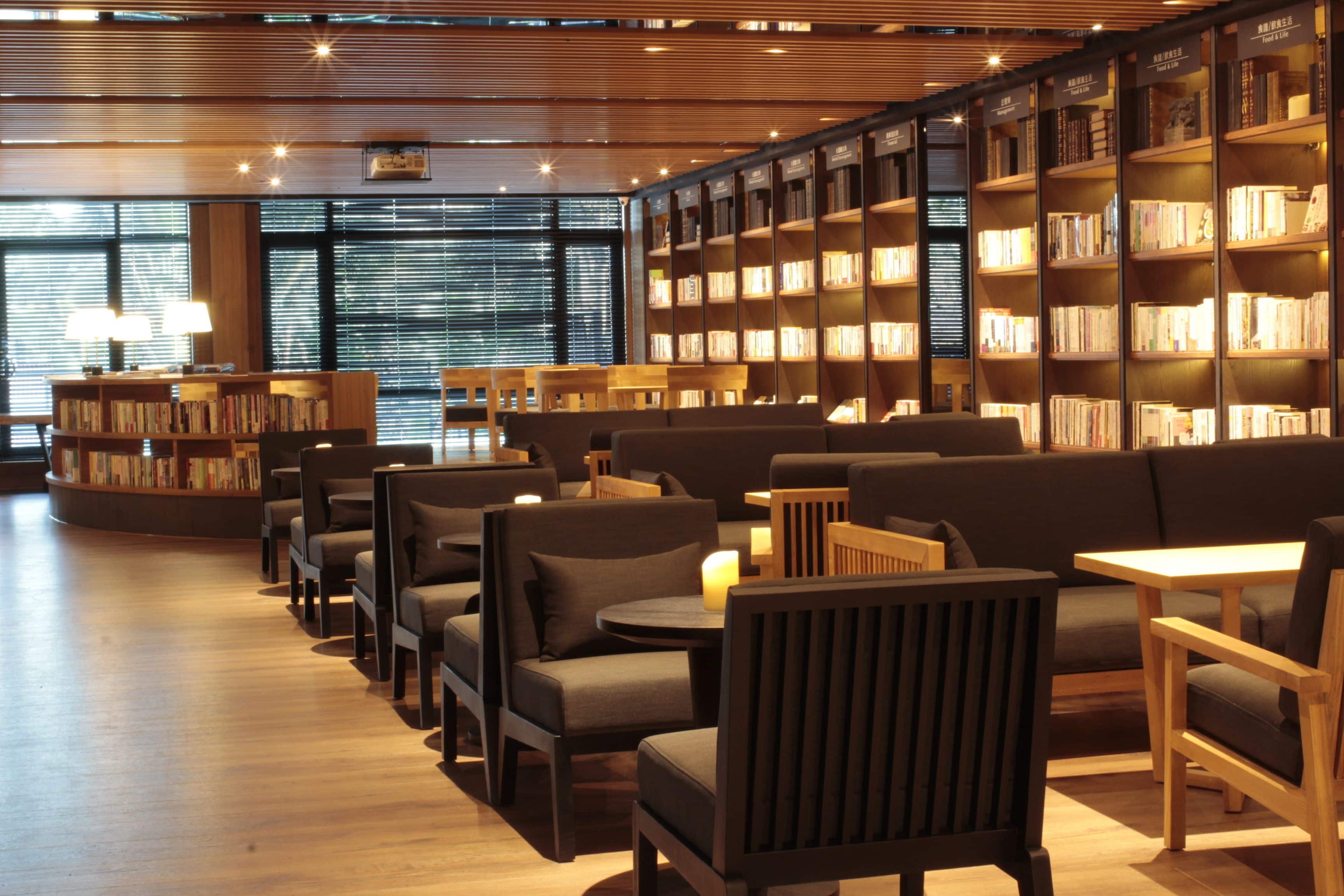 A library with bookshelves, seating areas, and tables.