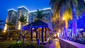 A hotel with a covered outdoor area, palm trees, and a pathway leading to the entrance. - Queena Plaza Hotel Tainan (Tainan)