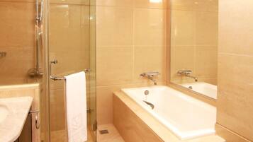 Un baño moderno con cabina de ducha de vidrio, bañera y retrete.