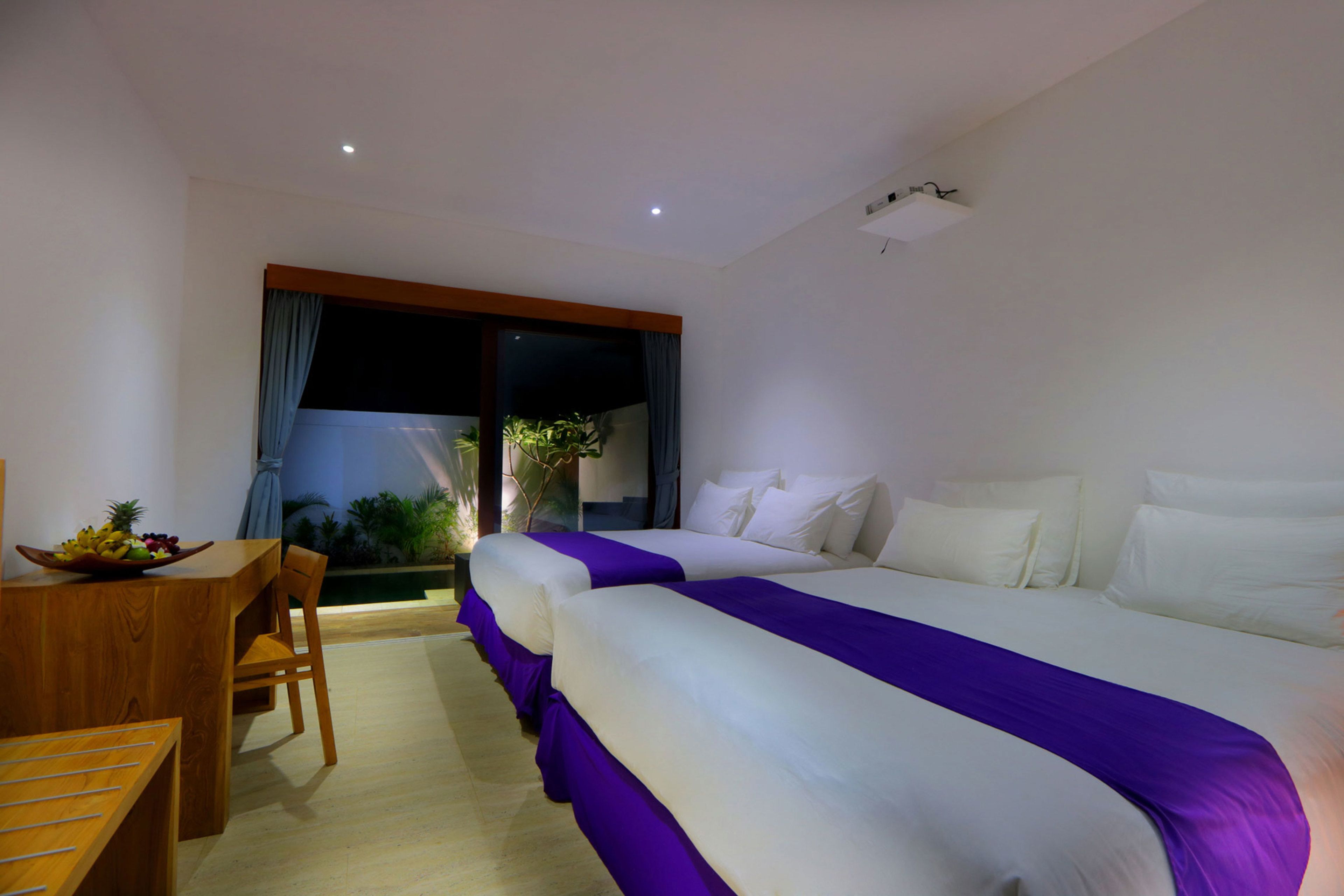Quarto de hotel com uma cama grande, uma escrivaninha de madeira e uma mesa de jantar.