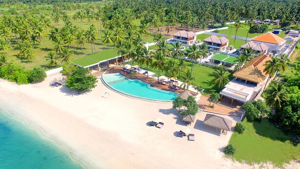 A resort with a swimming pool, beach, and palm trees. - Anema Wellness & Resort (Tanjung)