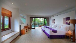 A modern hotel room with a large bed, a desk, and a view of a pool and greenery. - Anema Wellness & Resort (Tanjung)