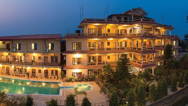 A multi-story hotel with a swimming pool, balconies, and a garden area. - Hotel Royal Safari (Sauraha)