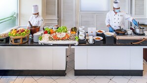 A buffet setup with various food items and two chefs preparing dishes. - Kantary Bay Hotel And Serviced Apartments (Si Racha)