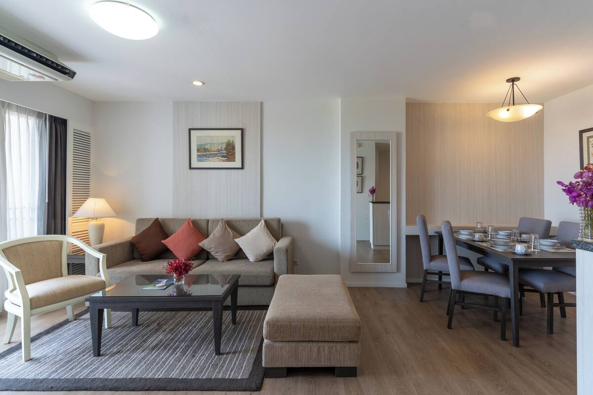 Ein modernes Wohnzimmer mit Sofa, Couchtisch und Essbereich.