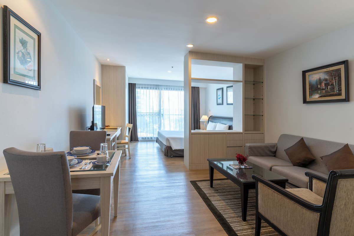 Ein modernes Hotelzimmer mit Essbereich, einer Couch und einem Bett.