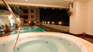 An indoor swimming pool with a glass bottom, surrounded by lounge chairs and potted plants. - Kantary Bay Hotel And Serviced Apartments (Si Racha)
