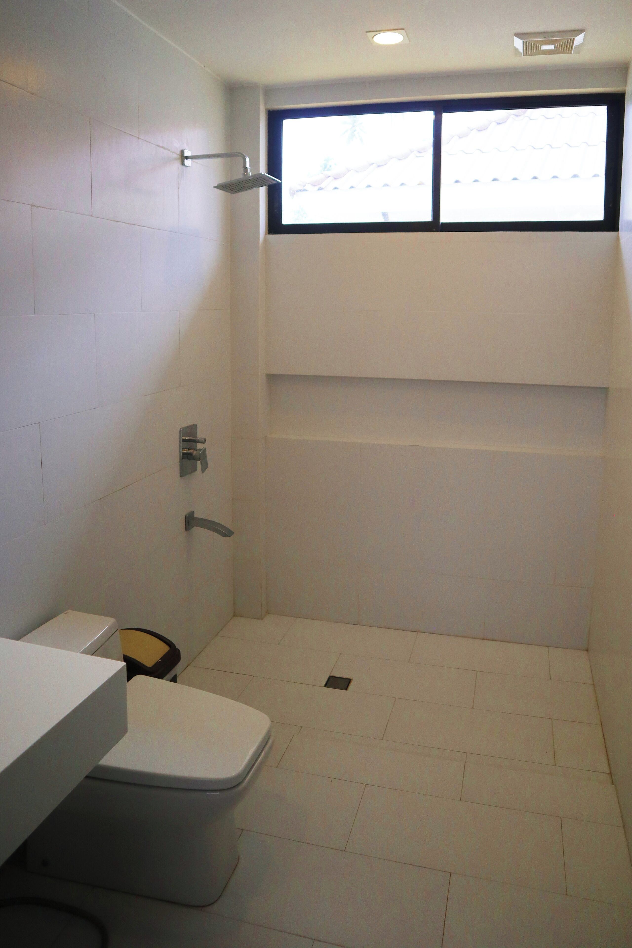 A bathroom with a toilet, sink, and shower area.