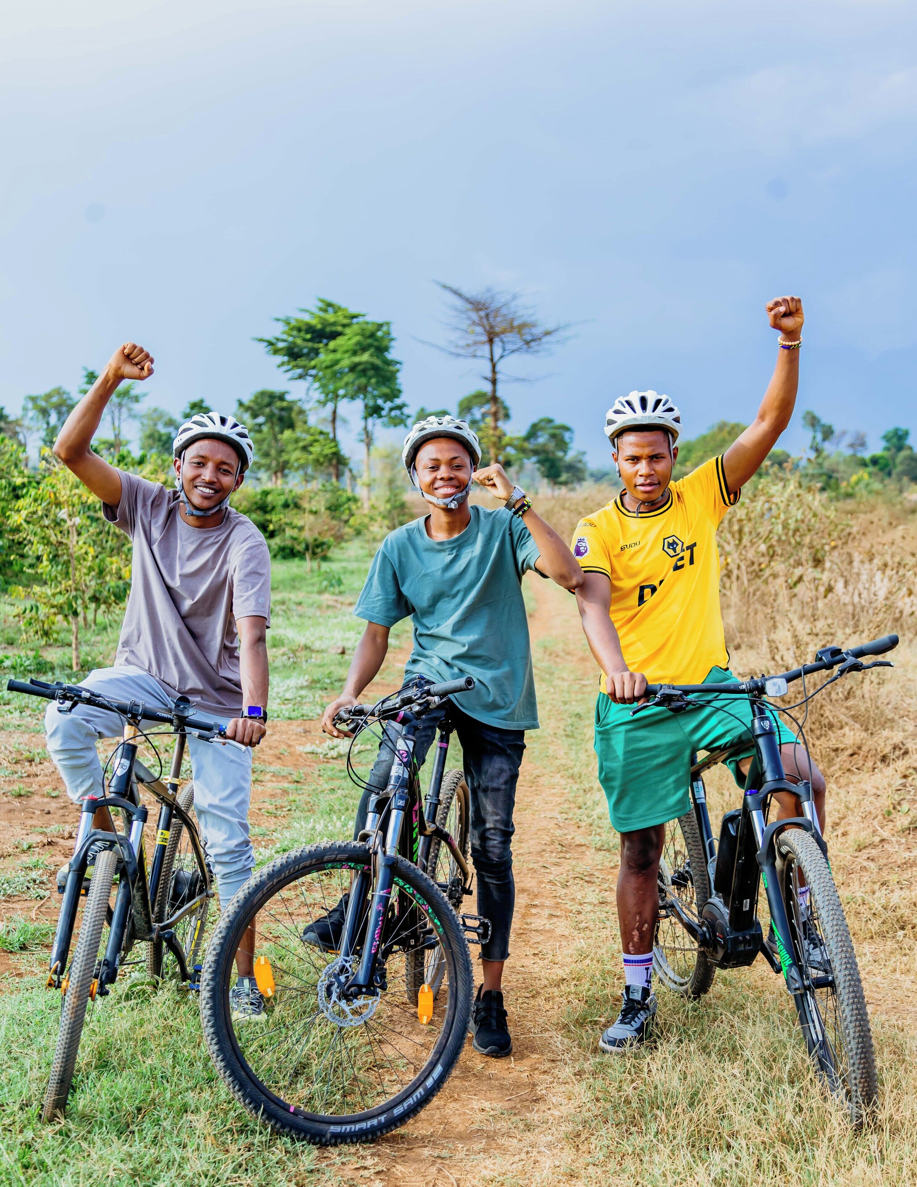 Três pessoas em bicicletas de montanha em um cenário natural.