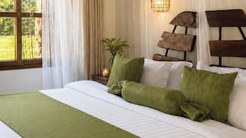 A bed with a green bedspread, white linens, and a wooden headboard.