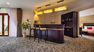 A bar area with a patterned carpet, a potted plant, and a seating arrangement.