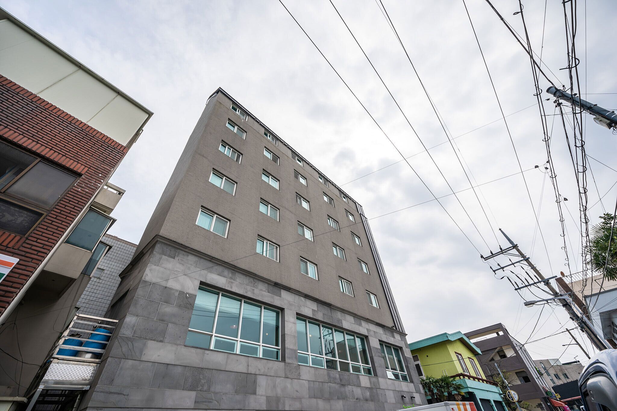A multi-story building with a modern architectural style, featuring a flat roof and a series of windows.