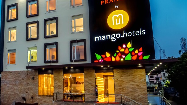 A multi-story building with a large illuminated sign for Prangan by mango hotels, featuring a tree logo and a mango symbol. - Mango Hotels Prangan, Bhubaneshwar (Bhubaneshwar)
