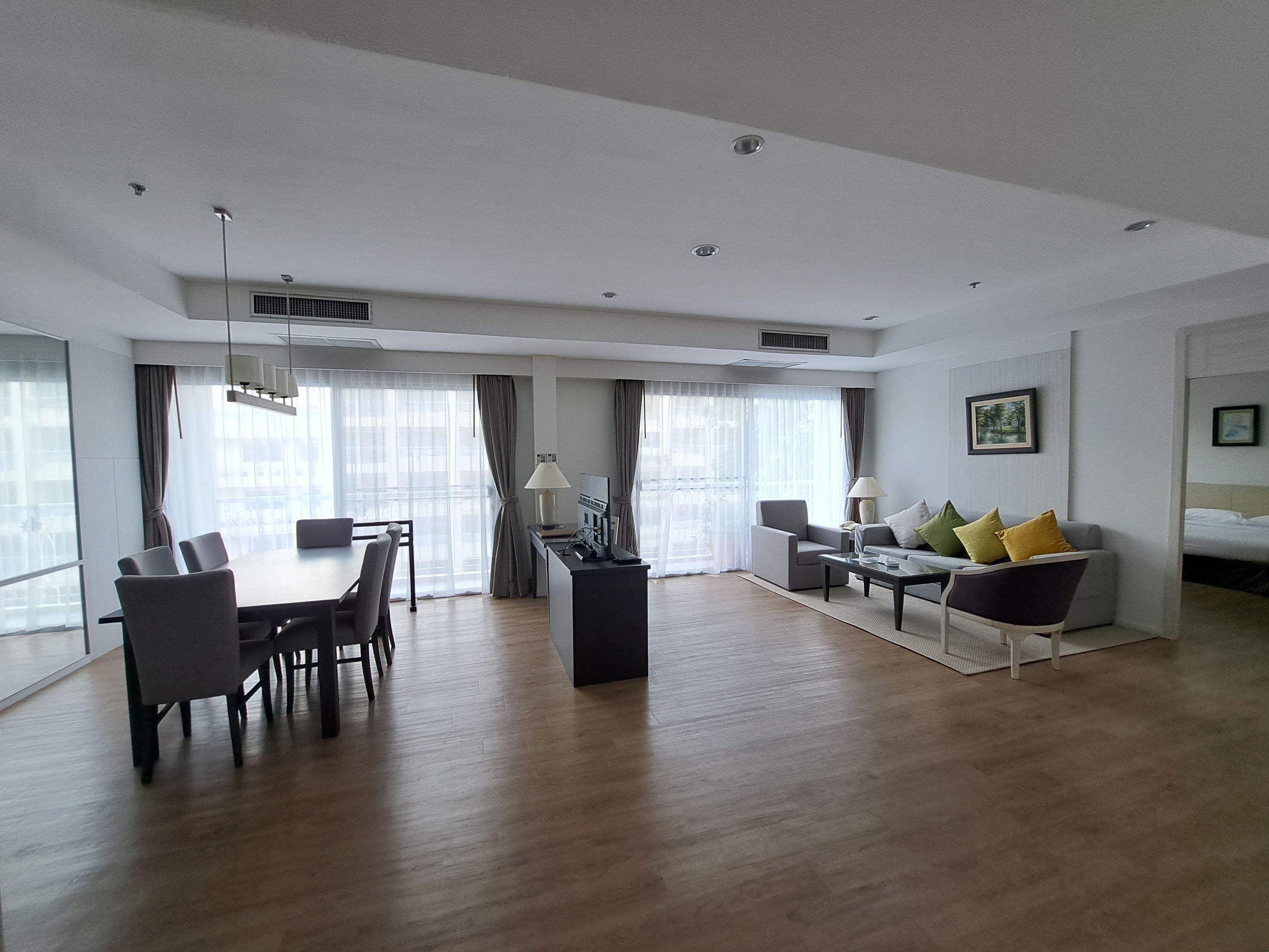 Une chambre d’hôtel moderne comprenant un coin repas, un ensemble de canapés et un lit.
