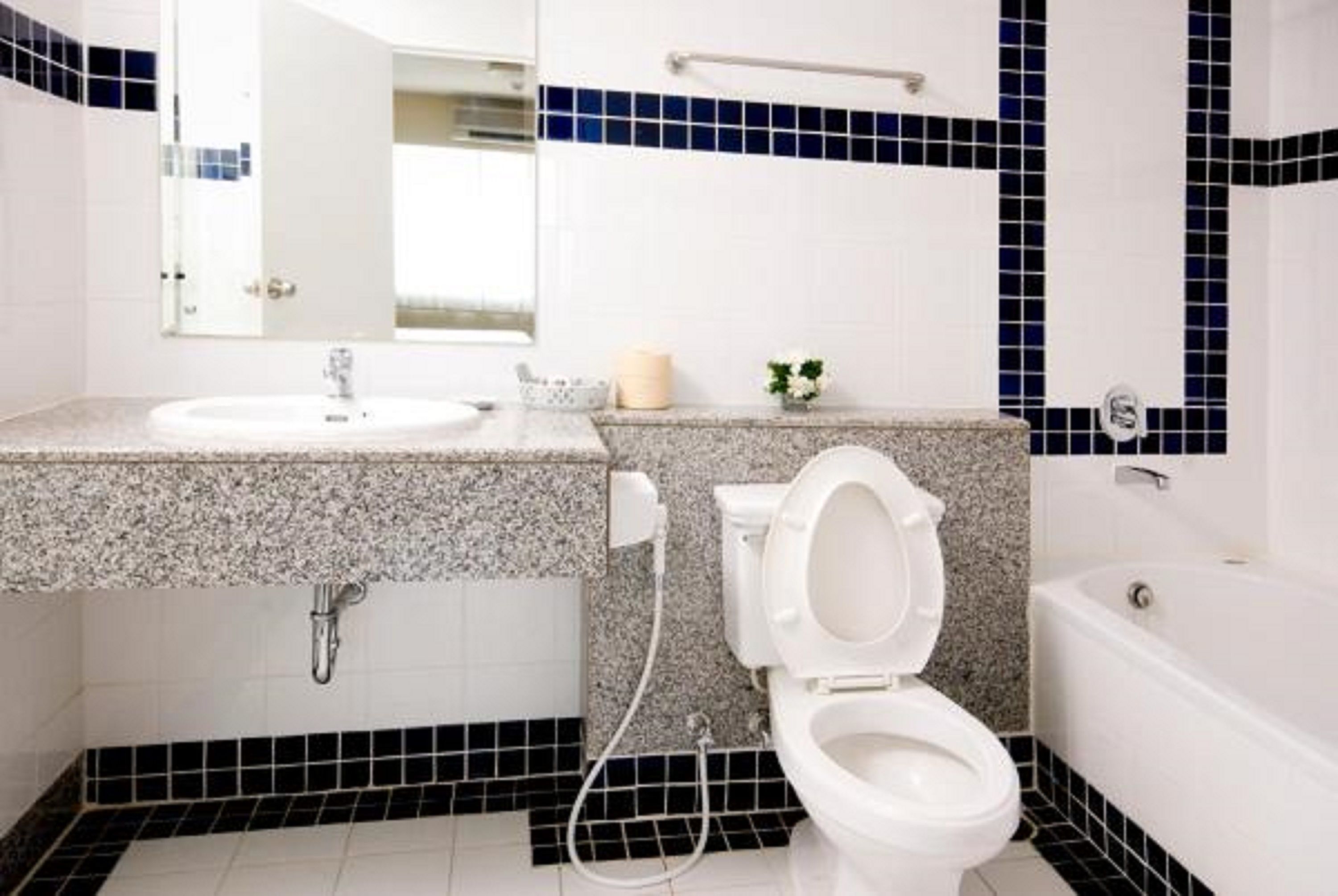Une salle de bain avec un lavabo, des toilettes et une baignoire, le tout de couleur blanche.