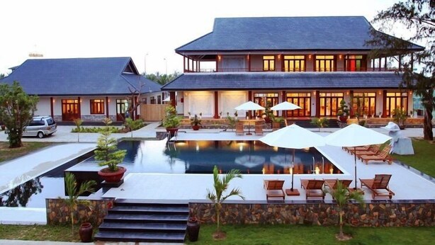 A two-story house with a swimming pool, outdoor seating, and a well-maintained garden. - Aniise Villa Resort (Ninh Chu)