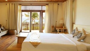 A hotel room with a bed, a TV, a desk, and a balcony with curtains. - Aniise Villa Resort (Ninh Chu)