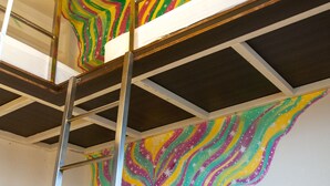 A bunk bed with a ladder, a colorful mural on the wall, and a white ceiling light. - Heng-Zhan Inn (Hengchun)
