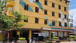 A multi-story building with a yellow facade and large floral window designs. - Heng-Zhan Inn (Hengchun)